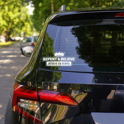 Clear vinyl “Repent & Believe – Jesus Is King” decal displayed on a car window, crown-shaped Christian sticker with white bold lettering.